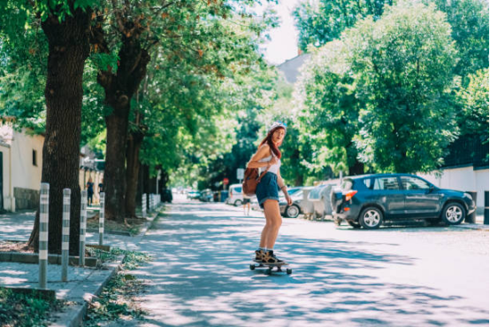 Longboard cruising down a sunny city street, embracing weekend freedom.