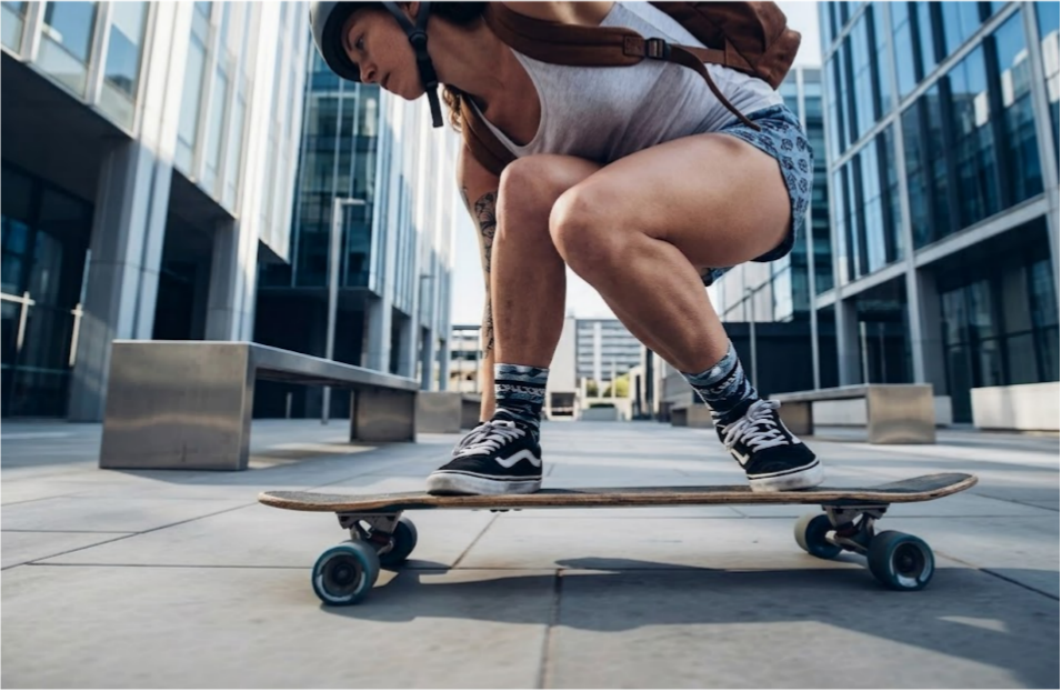 Beginner rider practicing foot braking on a longboard — flat ground, correct technique