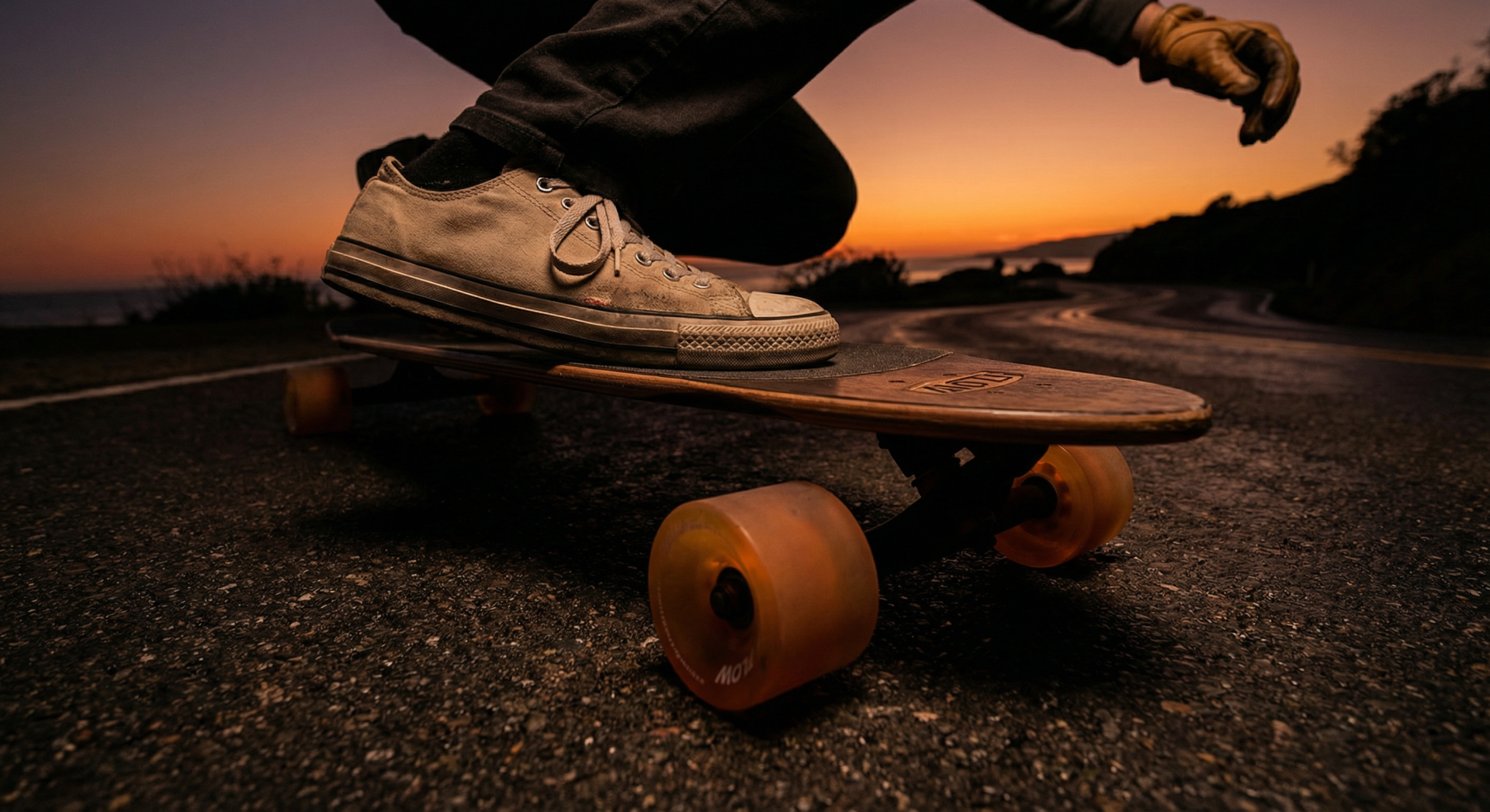 Low angle shot of a longboarder carving on smooth pavement