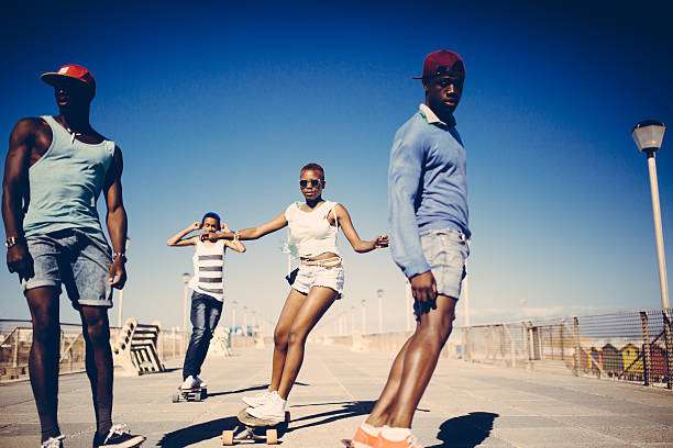 Diverse group of friends enjoying a sunny day, with one person riding a longboard.