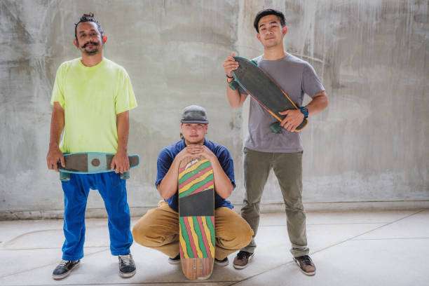 Three stylish men posing with their longboards indoors, ready for a ride.