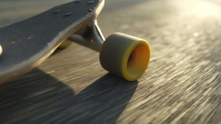 Close-up of a longboard wheel rolling on asphalt in golden sunlight.