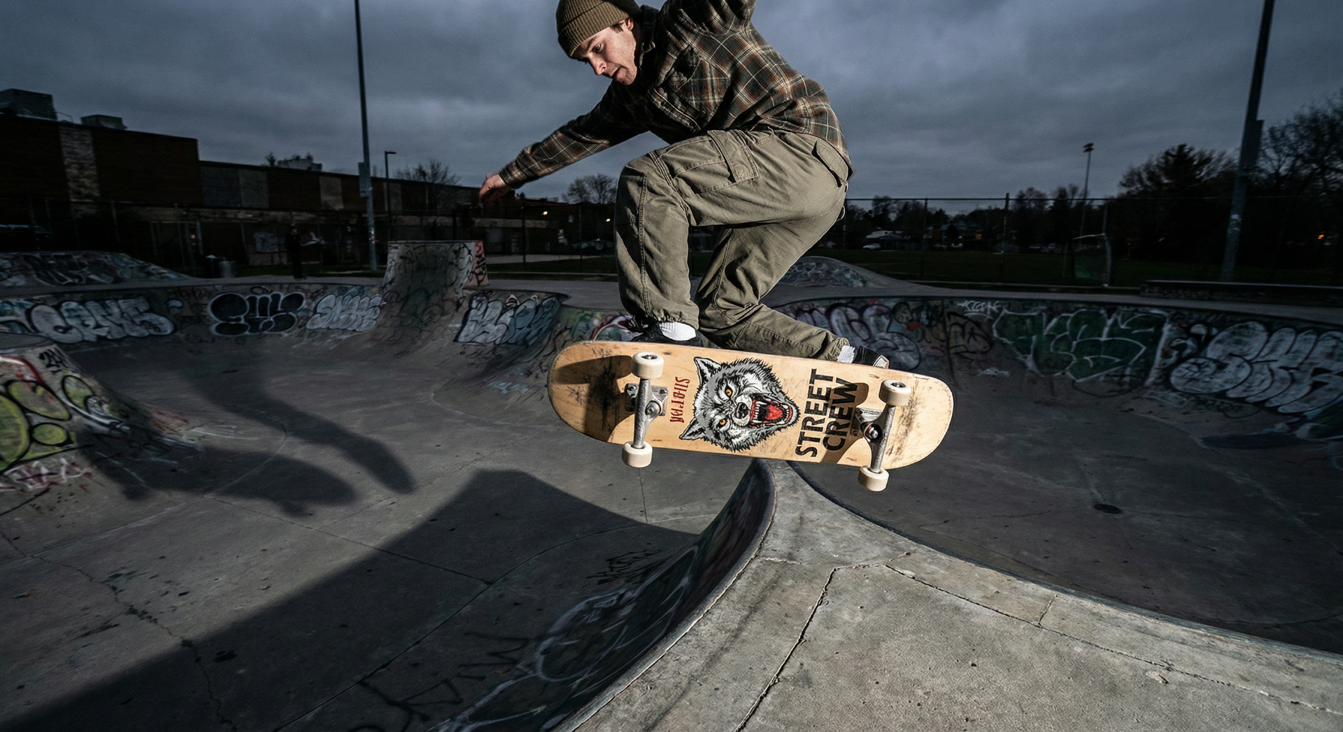 Skateboarder executing a kickflip mid-air over a gap in a concrete skatepark