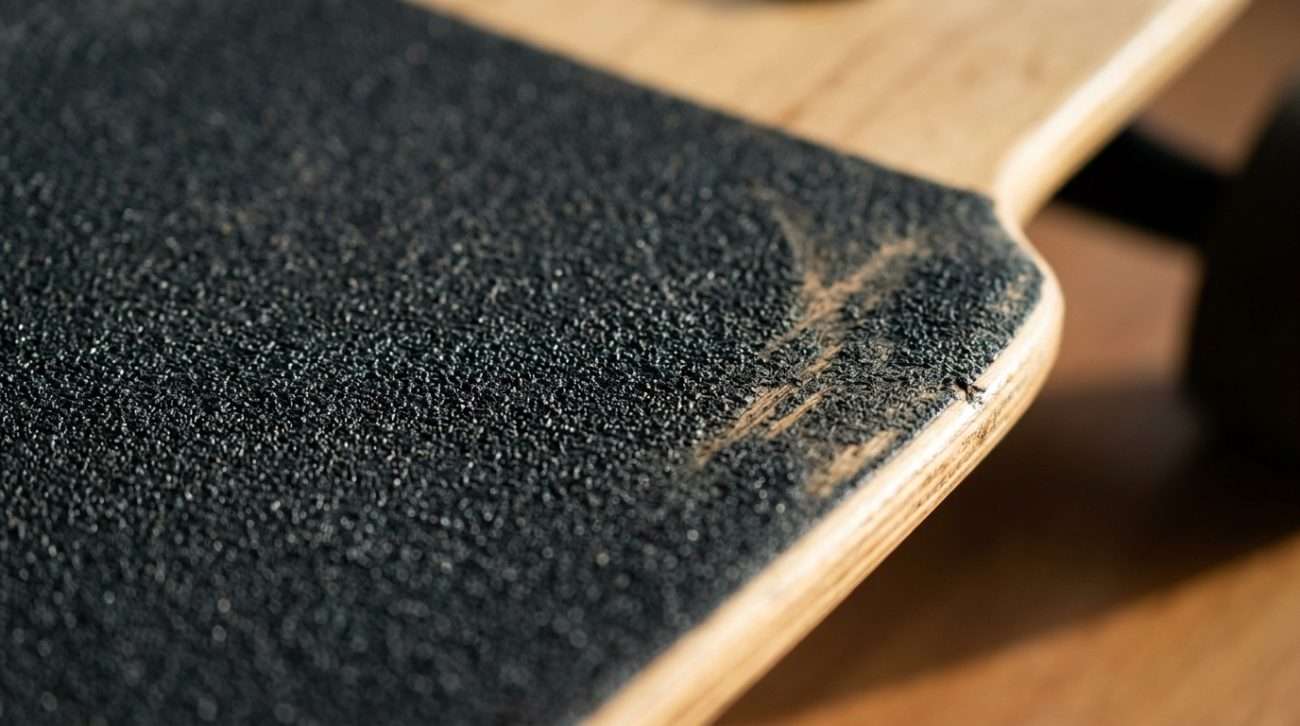 Close-up of longboard grip tape texture on a maple deck